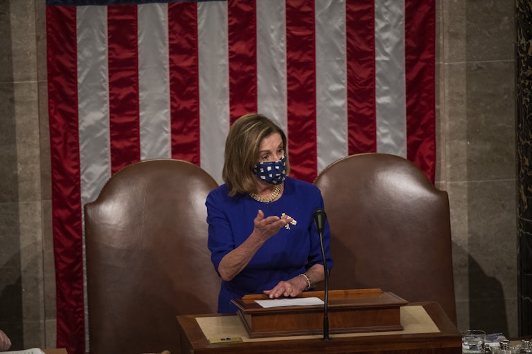 Nancy Pelosi wears a mask and gestures as she speaks in the Capitol on January 6, 2021. She is wearing a face mask.