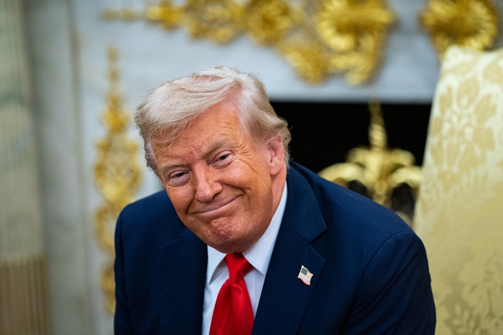 Donald Trump smiles weirdly in his gold-filled Oval Office