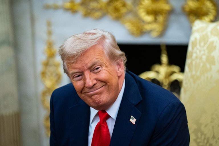 Donald Trump smiles weirdly in his gold-filled Oval Office
