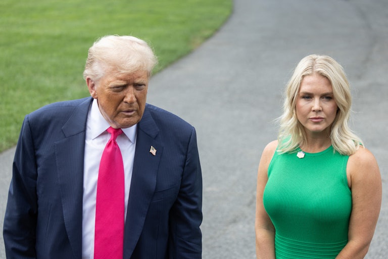 Donald Trump and Karoline Leavitt stand next to each other outside the White House