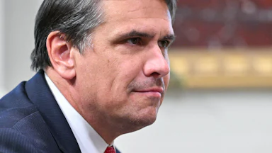 Acting Attorney General Todd Blanche leans forward and smirks