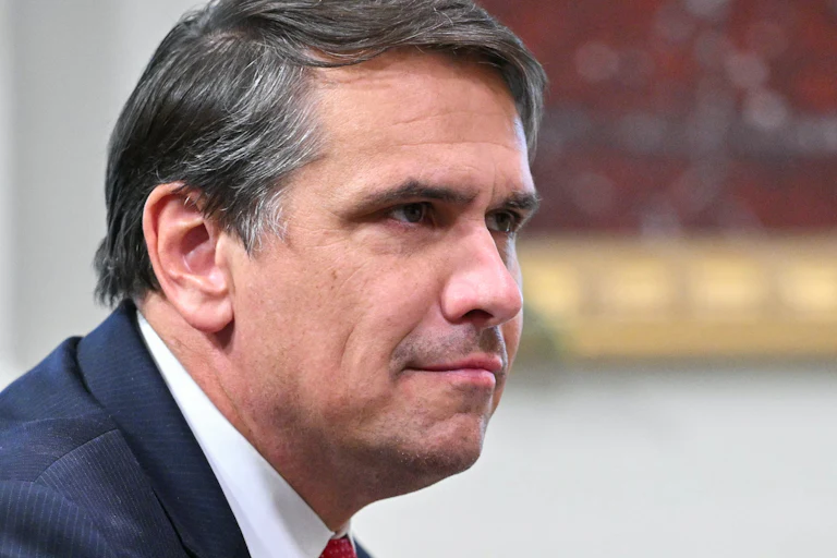 Acting Attorney General Todd Blanche leans forward and smirks