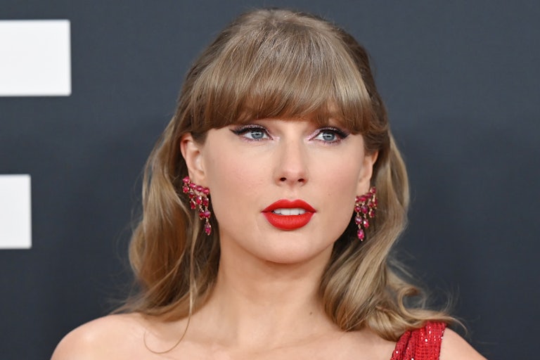 Taylor Swift stands on the red carpet at the Grammy Awards