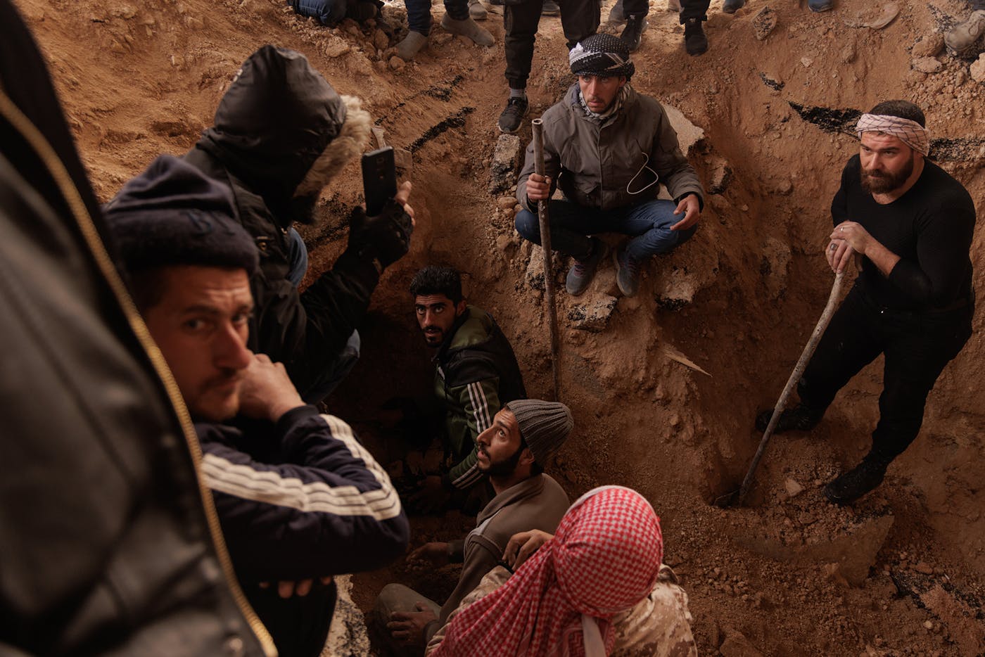 A group of men digging a tunnel in an area behind the prison leading to the hills that surround the main building of the prison. 