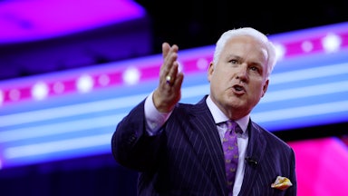 Matt Schlap speaks on stage while pointing