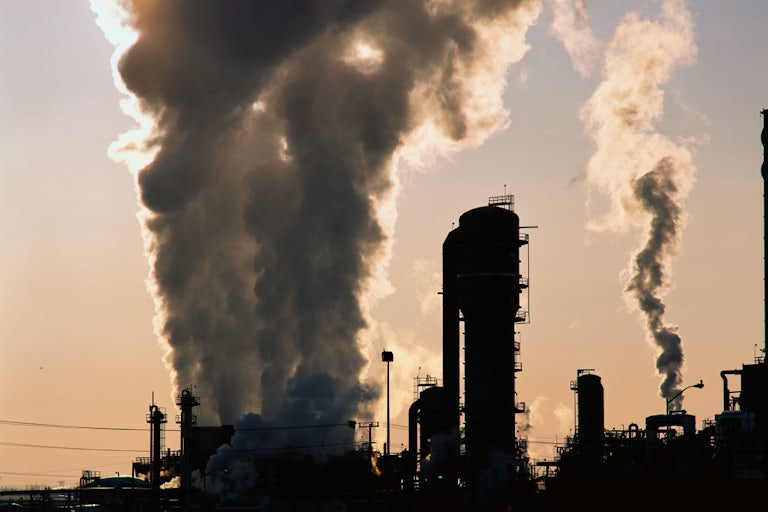 Smokestacks release giant plumes of smoke into the sky.
