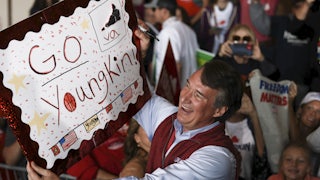 Republican Glenn Youngkin holds up a handmade sign