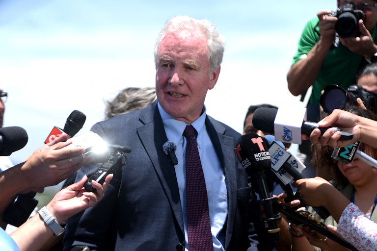 Senator Chris Van Hollen is surrounded by reporters’ microphones on his trip to El Salvador to visit the wrongly deported immigrant Kilmar Abrego Garcia.