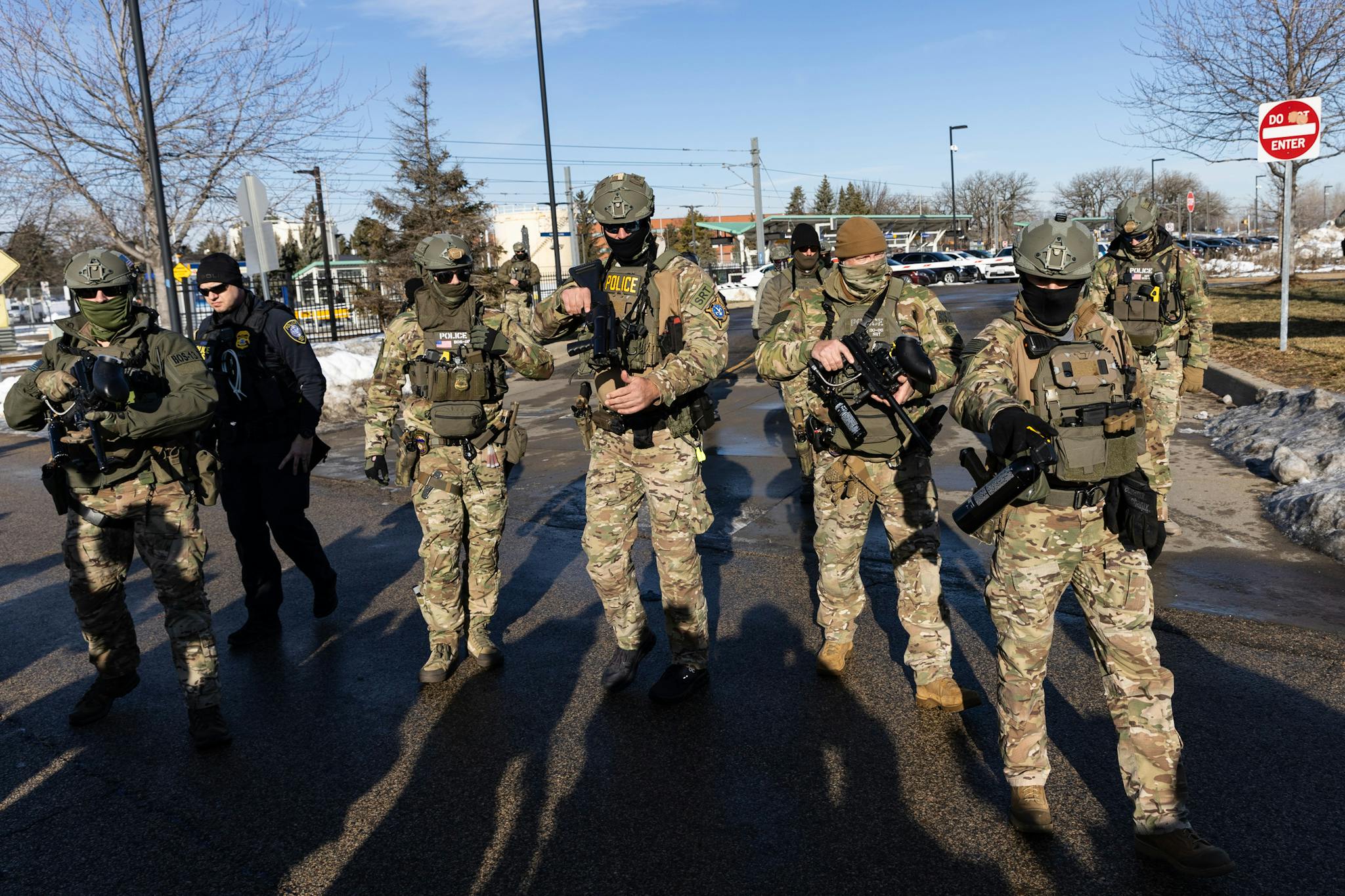 Masked ICE agents carry large guns outdoors