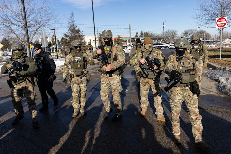 Masked ICE agents carry large guns outdoors