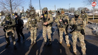 Masked ICE agents carry large guns outdoors