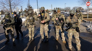 Masked ICE agents carry large guns outdoors