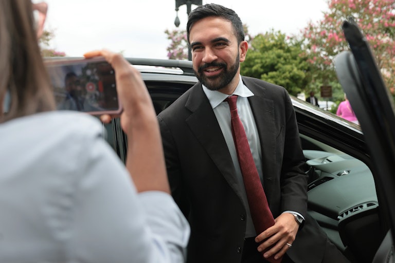 NYC Democratic mayoral nominee Zohran Mamdani gets out of a car as someone takes a photo of him on their phone.