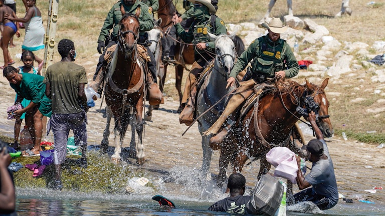 Border Patrol agents on horseback charge at Haitian migrants at the Rio Grande