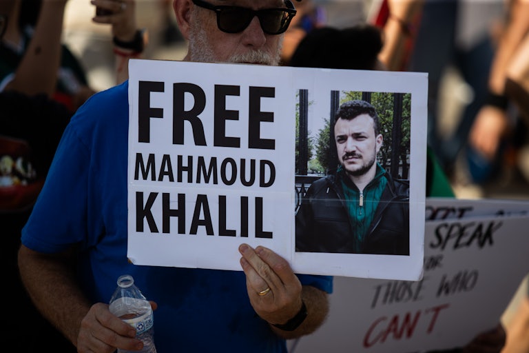A person holds up a sign that says "Free Mahmoud Khalil"