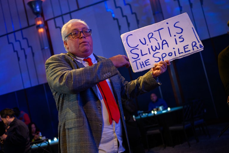 A man holds a sign that says, "Curtis Sliwa is the spoiler" at Andrew Cuomo's mayoral election night watch party