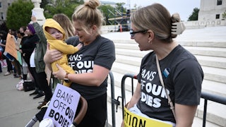 Two pro-choice demonstrators talk, as one holds a baby.