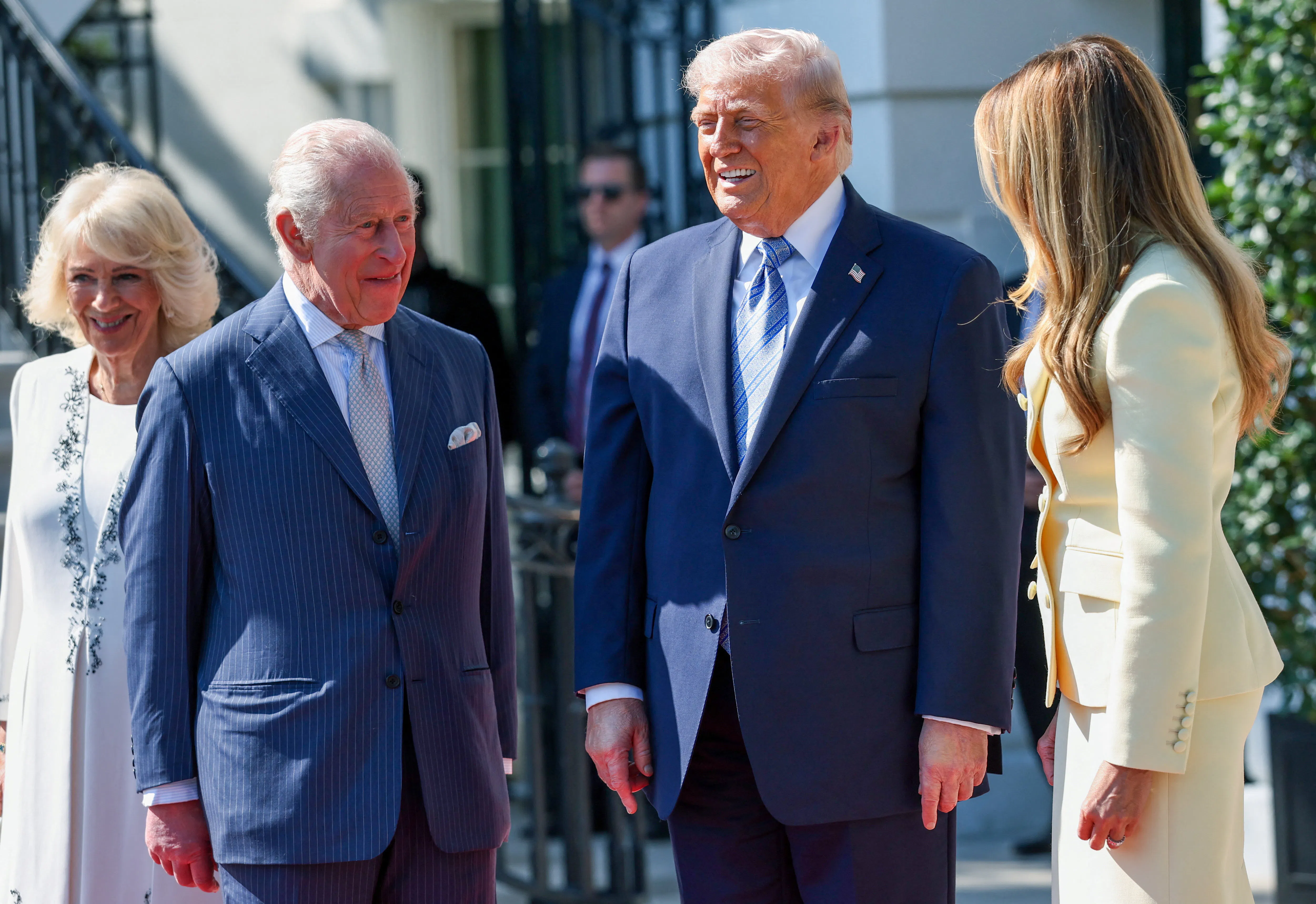 President Donald Trump and First Lady Melania Trump greet King Charles III and Queen Camilla at the White House, all of them smiling.