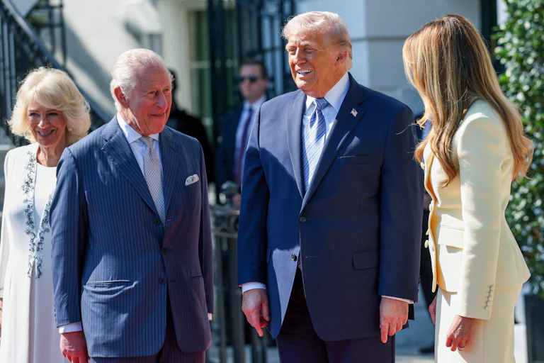 President Donald Trump and First Lady Melania Trump greet King Charles III and Queen Camilla at the White House, all of them smiling.