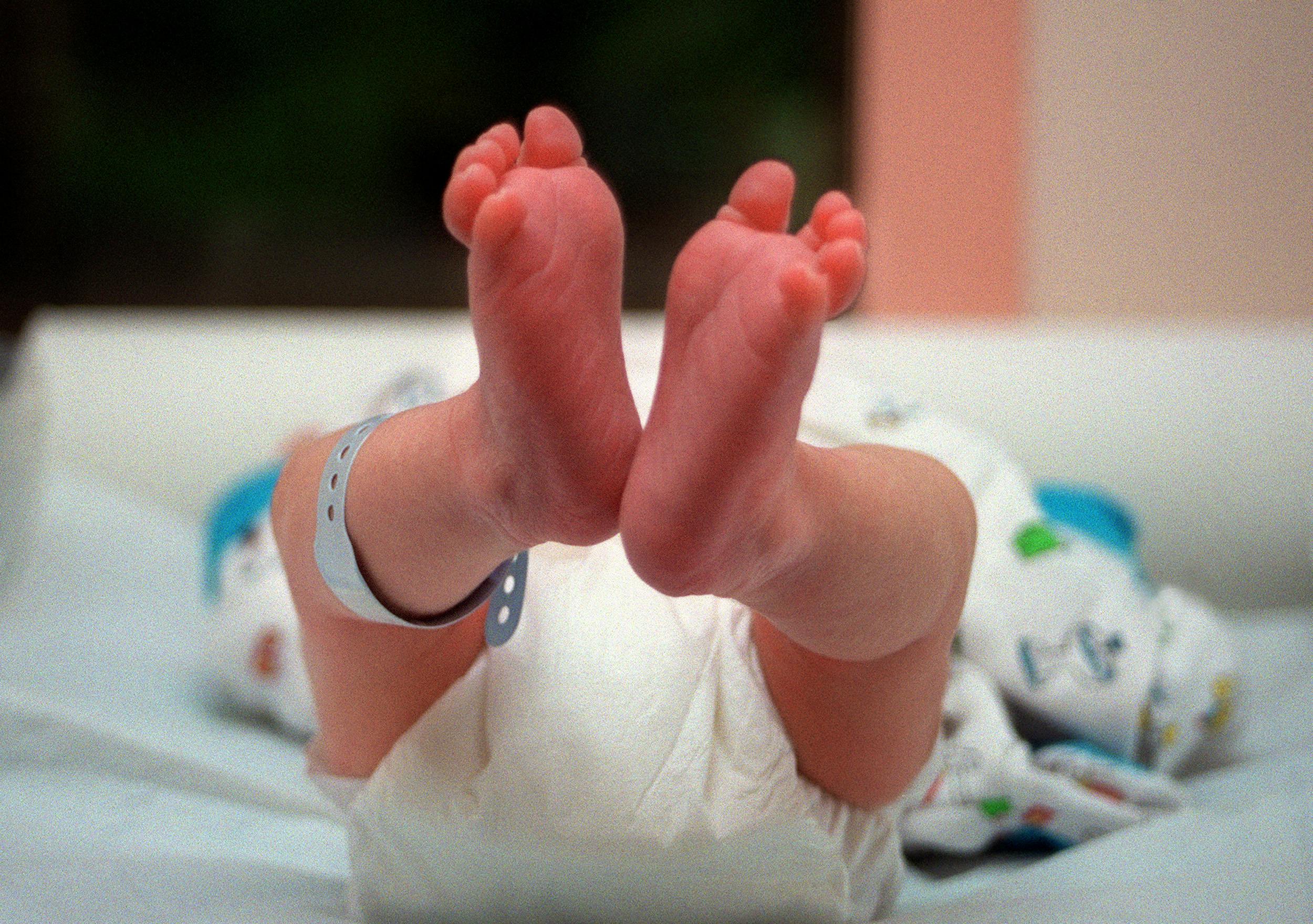 A newborn baby with its feet pointing toward the camera