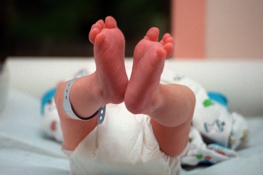 A newborn baby with its feet pointing toward the camera