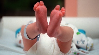 A newborn baby with its feet pointing toward the camera