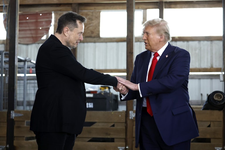 Donald Trump holds Elon Musk’s outstretched hand with both of his hands