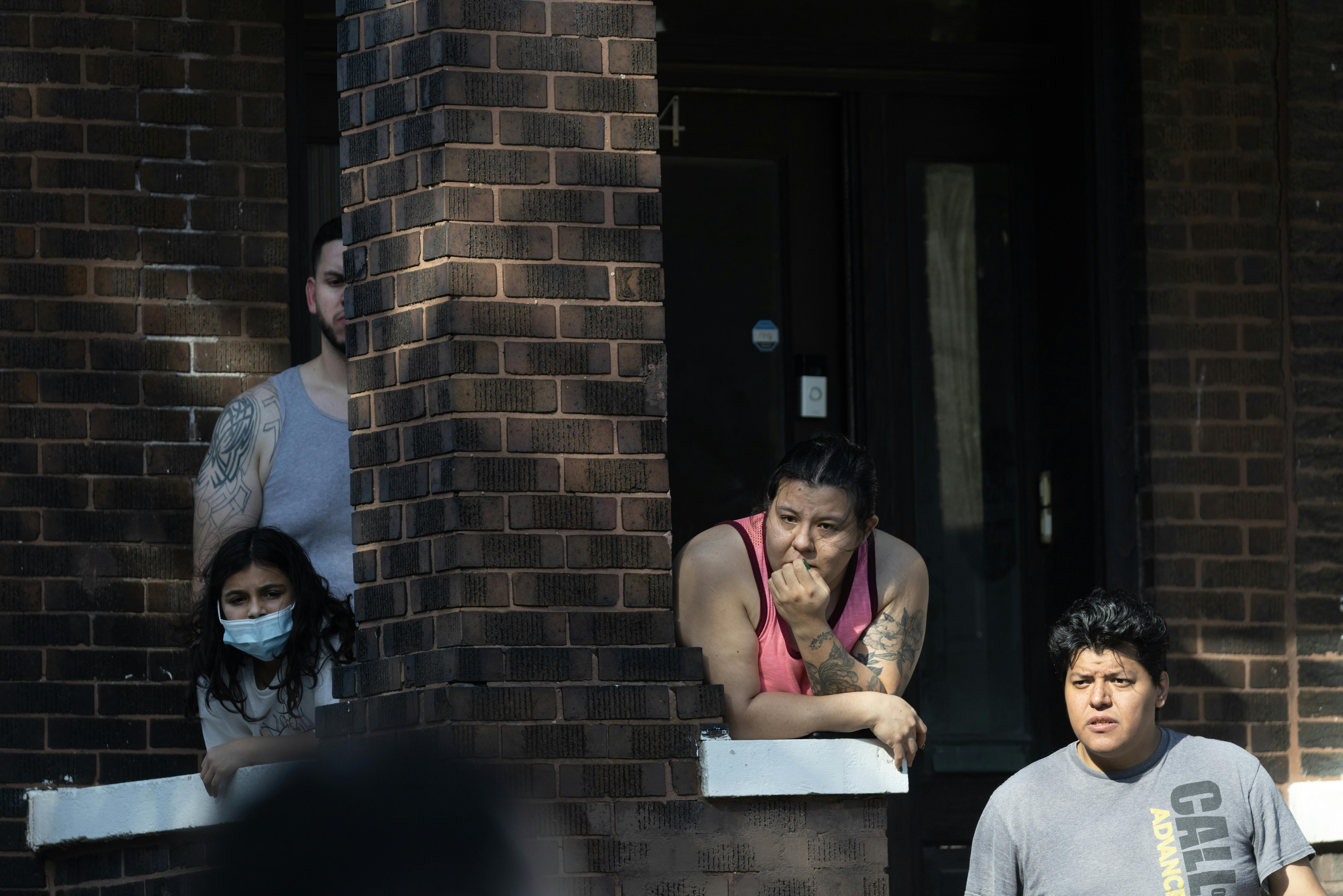 Four Chiago residents look out from their front stoop.