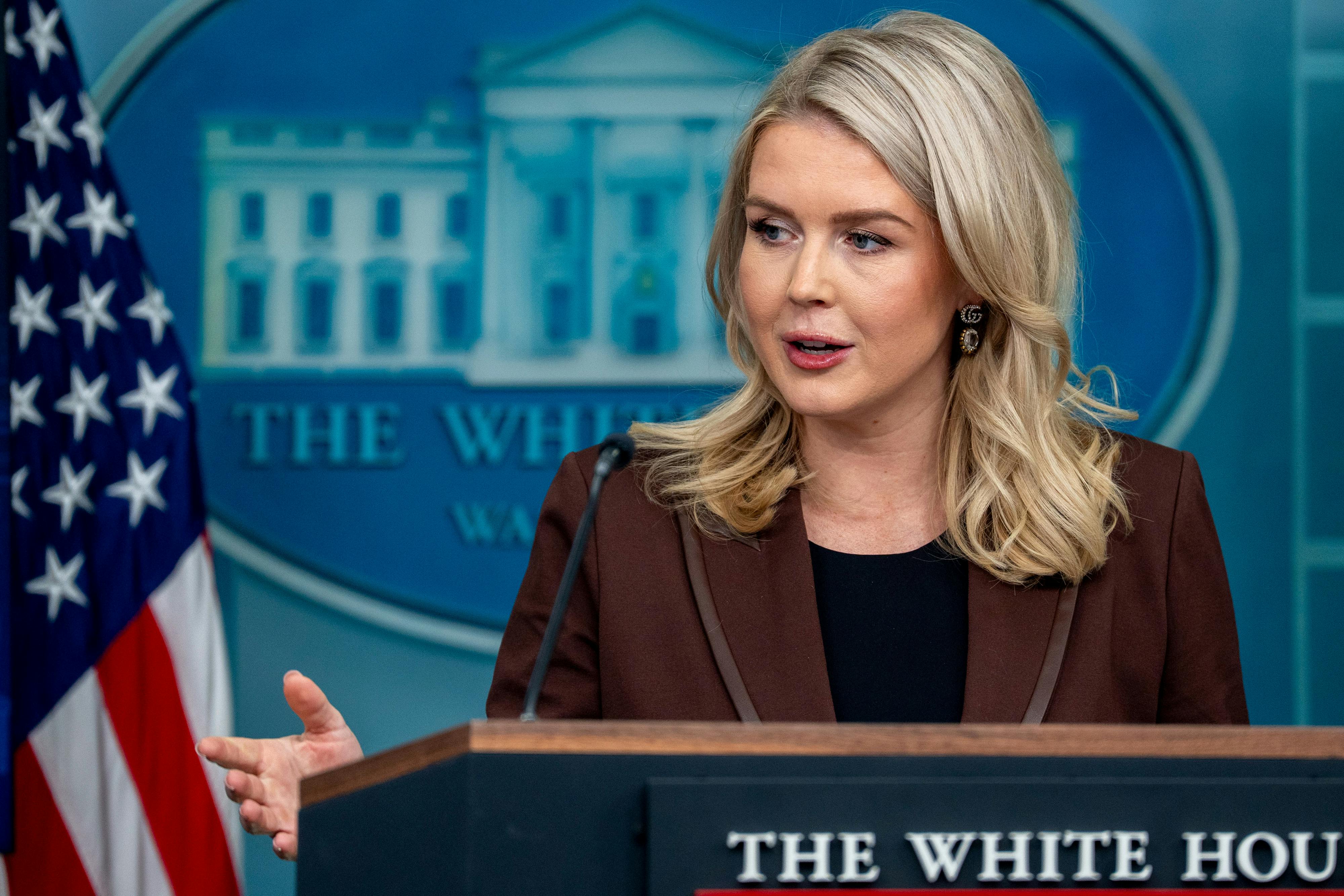 Karoline Leavitt gestures while speaking at the podium in the White House press briefing room