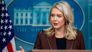 Karoline Leavitt gestures while speaking at the podium in the White House press briefing room