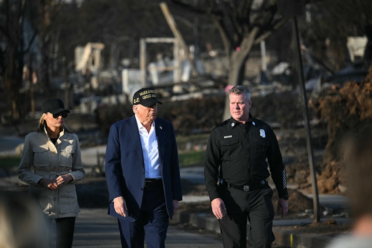 Donald Trump, Melania Trump, and an unnamed official walk through scorched streets.