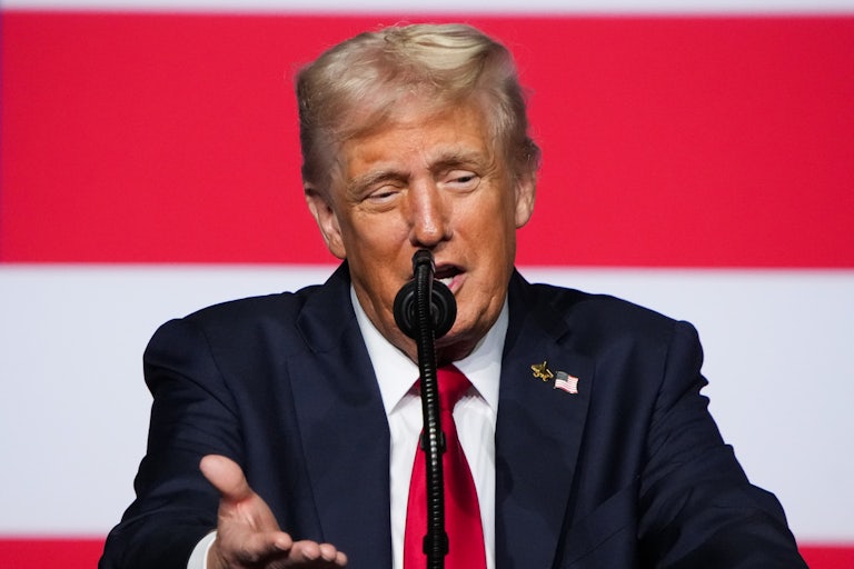 Donald Trump gestures while speaking at a podium