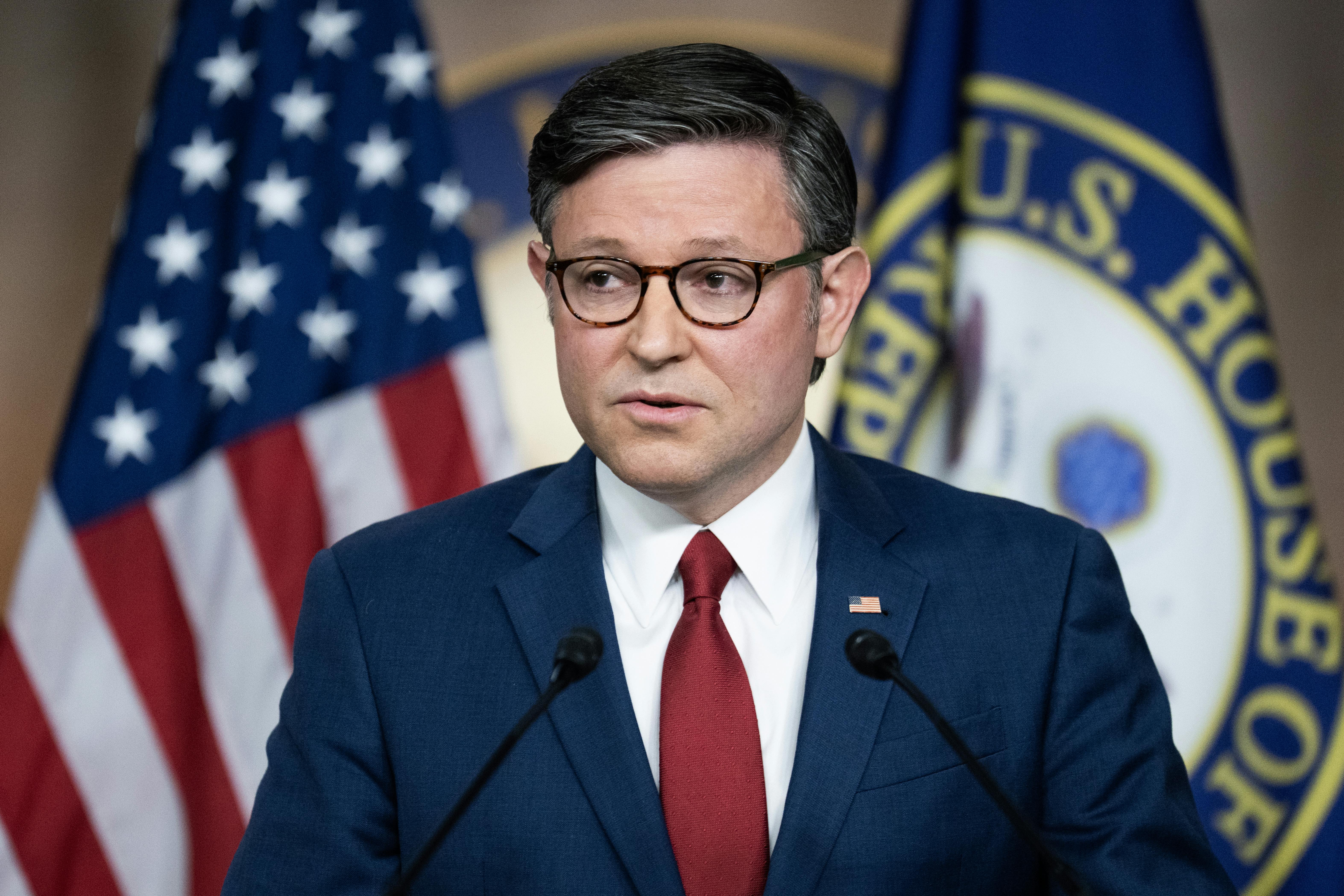 House Speaker Mike Johnson speaks at a podium 