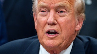 Donald Trump speaks while sitting at his desk in the Oval Office