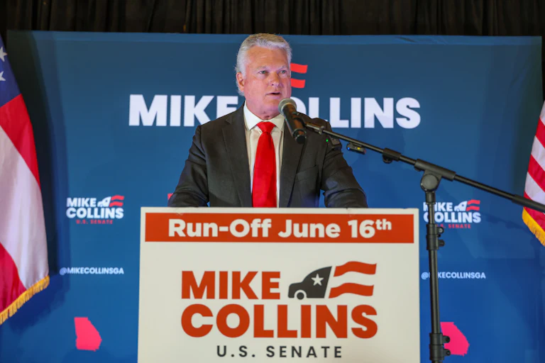 Representative Mike Collins speaks at a podium during a campaign event