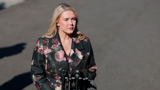 Press secretary Karoline Leavitt stands in front of reporters' microphones outside the White House