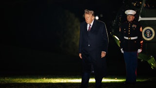 Donald Trump looks down while walking outside the White House