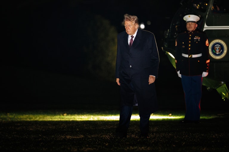 Donald Trump looks down while walking outside the White House