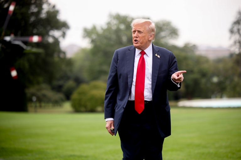 Donald Trump points to the side while speaking to reporters outside the White House