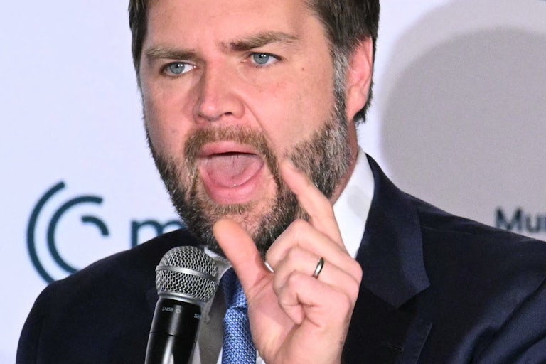 Vice President JD Vance gestures while speaking into a microphone