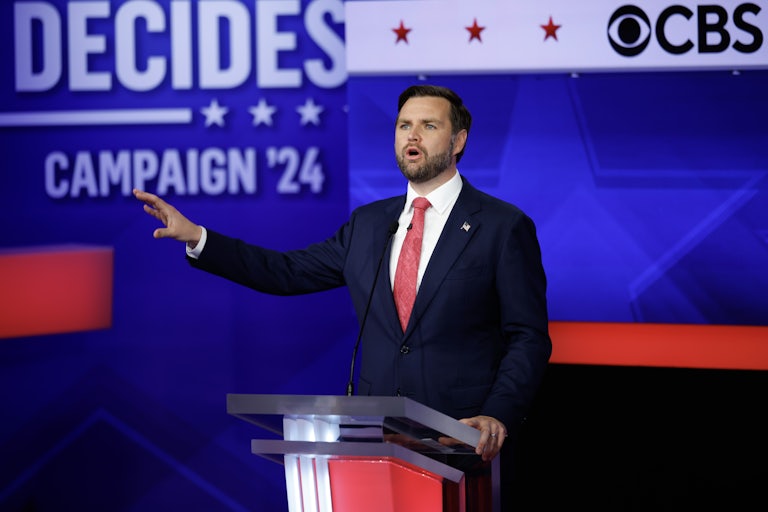 JD Vance gestures with one arm while speaking during the vice presidential debate