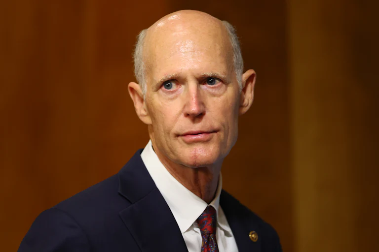 Rick Scott stares in a dejected manner
