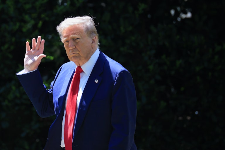 Donald Trump waves to the camera as he walks outside.