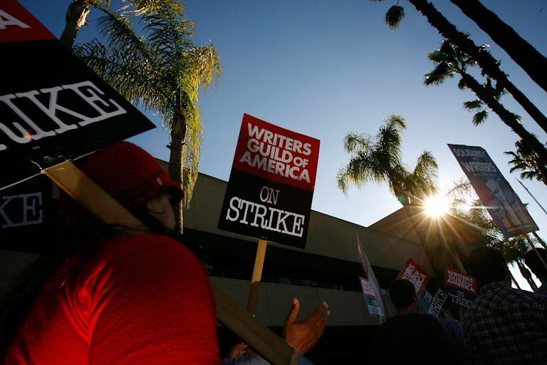 A sign reads Writers Guild of America On Strike!