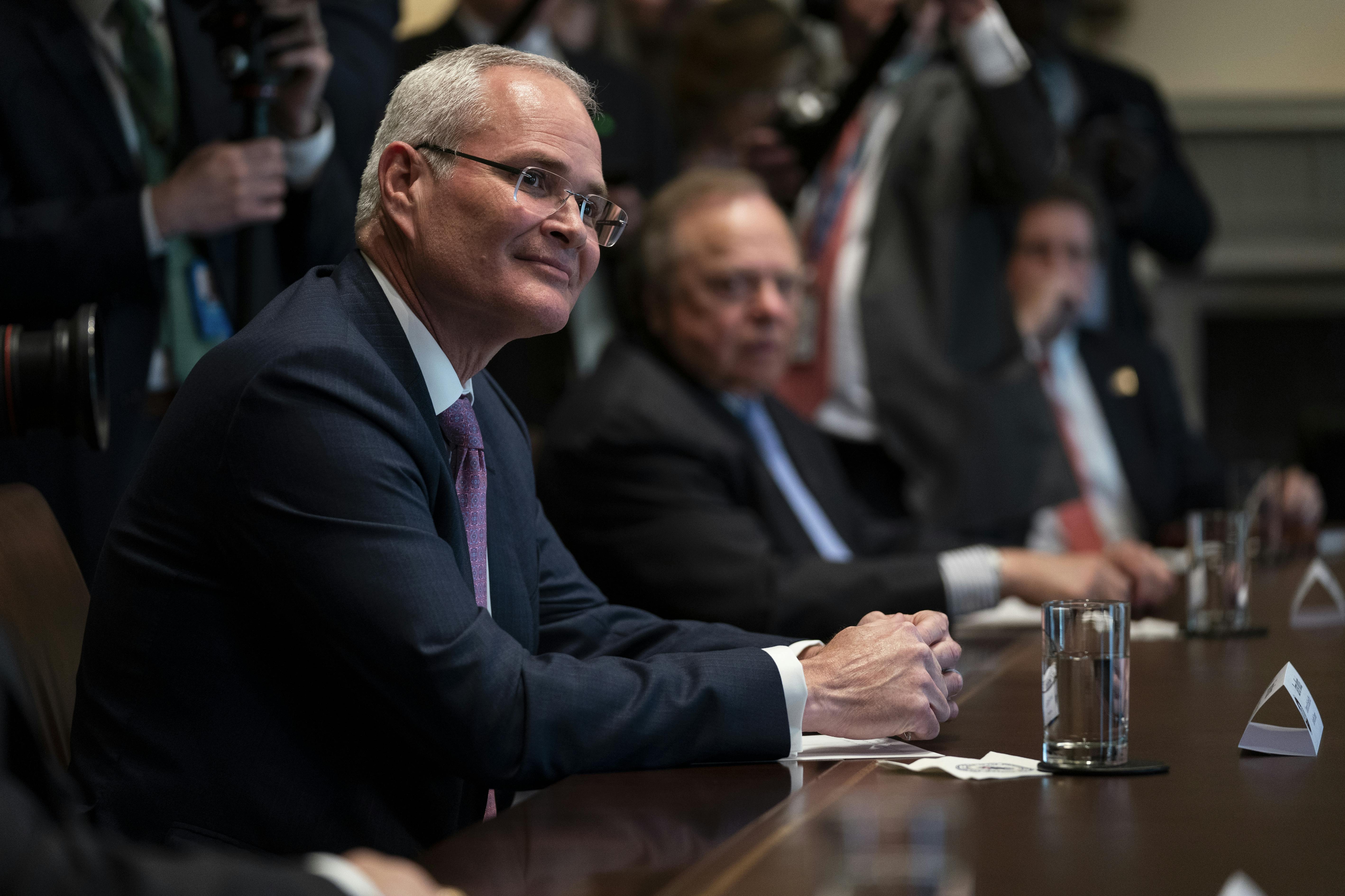 Exxon Mobil CEO Darren Woods appears seated during a meeting at the White House in April.