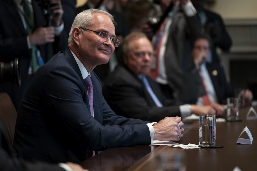 Exxon Mobil CEO Darren Woods appears seated during a meeting at the White House in April.