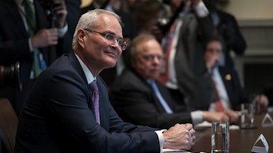 Exxon Mobil CEO Darren Woods appears seated during a meeting at the White House in April.