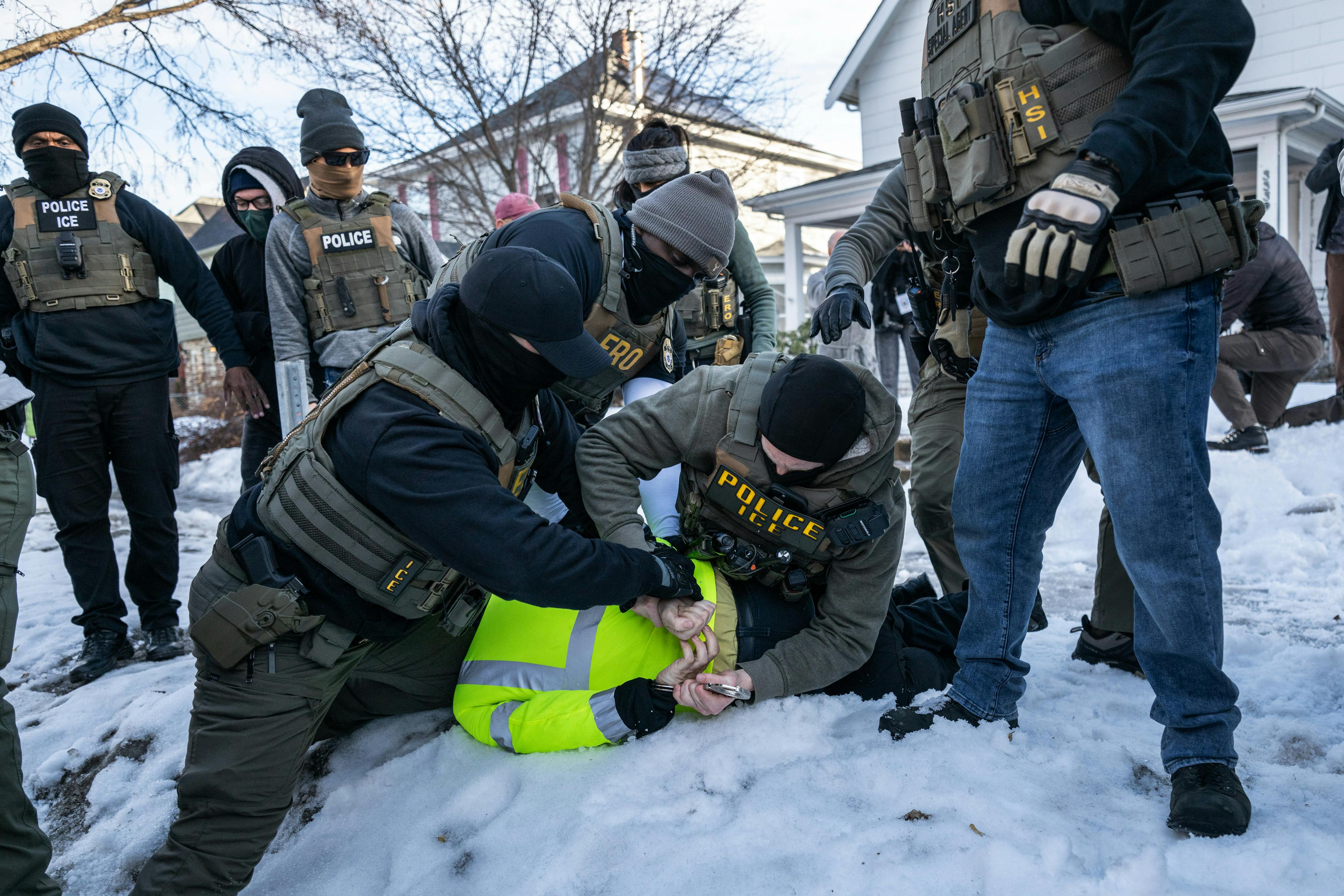 Federal law enforcement agents detain a demonstrator during a raid in south Minneapolis.