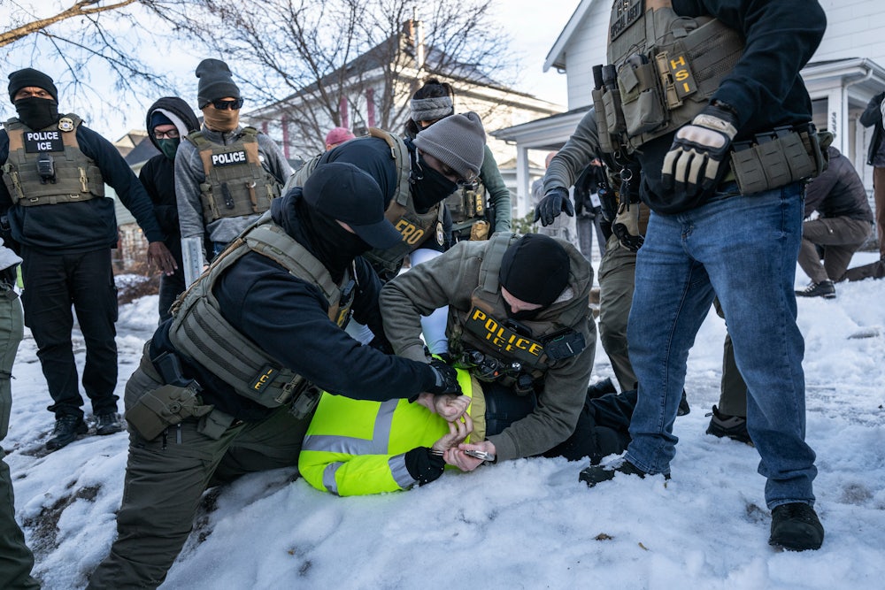 Federal law enforcement agents detain a demonstrator during a raid in south Minneapolis.