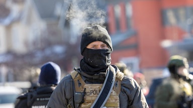 Masked federal immigration agents stand in Minneapolis, Minnesota, during protests